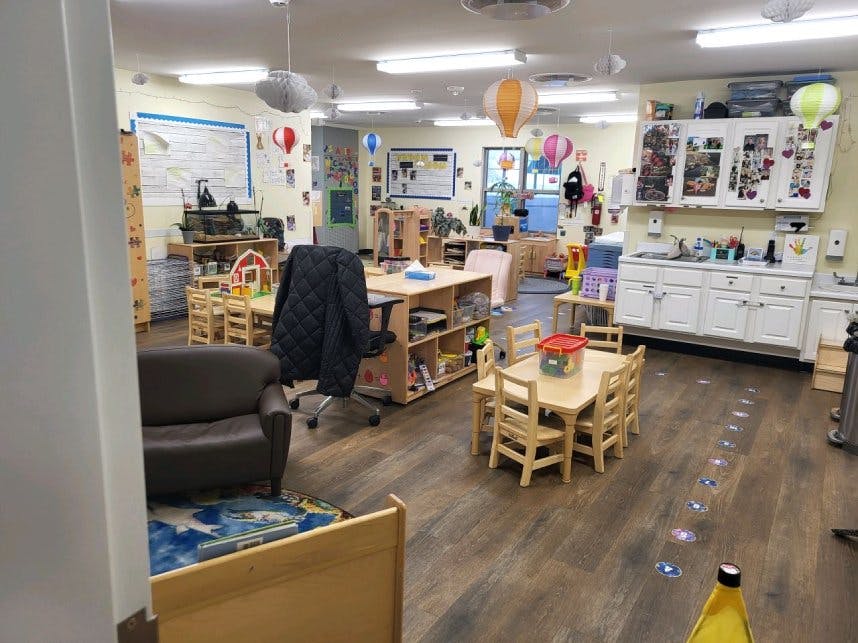 Classroom with small tables and chairs, a sofa, and cabinets