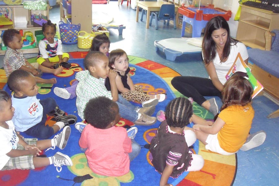 Adult reading to a group of children in a classroom