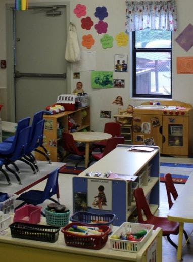 Classroom with small tables and chairs, decorated walls, and a window