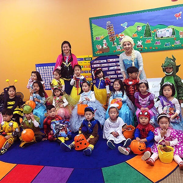 Adults and children in costumes sitting on the floor