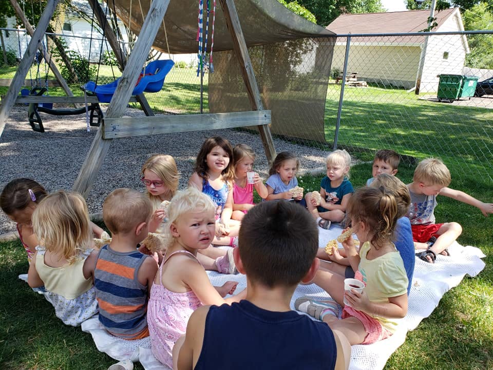 Group of children sitting on a blanket outdoors