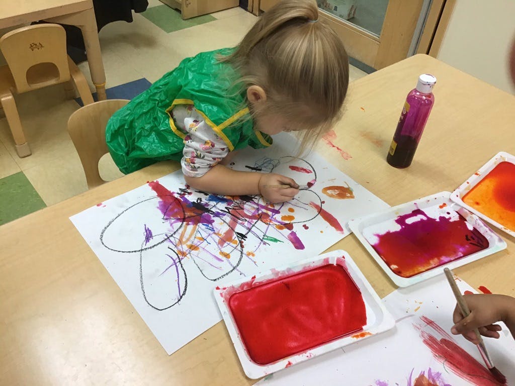 Child painting on paper at a table