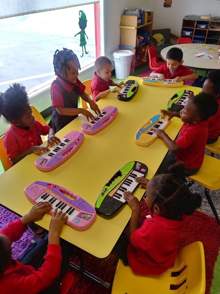 Children playing with toy keyboards at a table