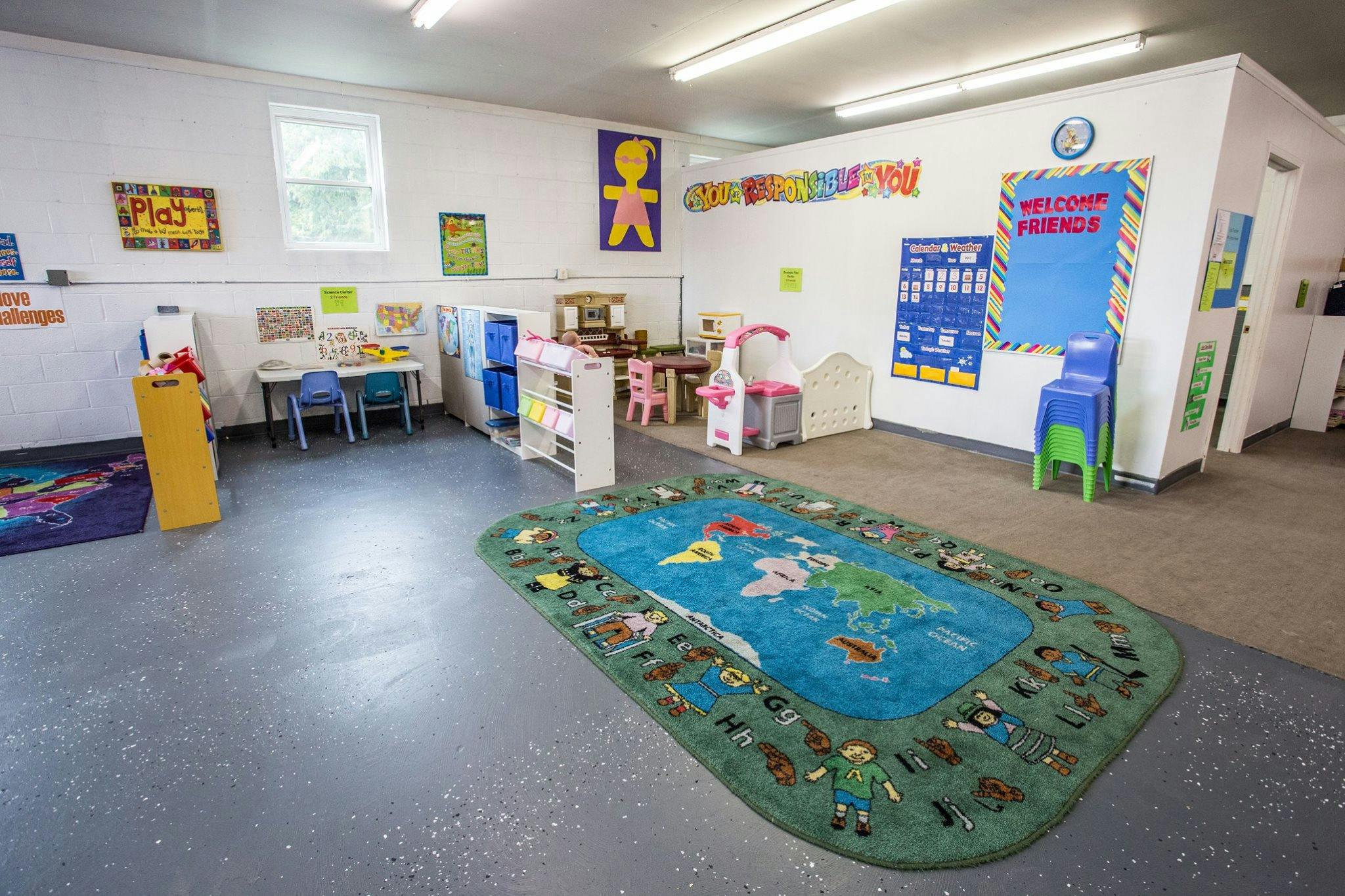 Playroom with a world map rug and small tables and chairs