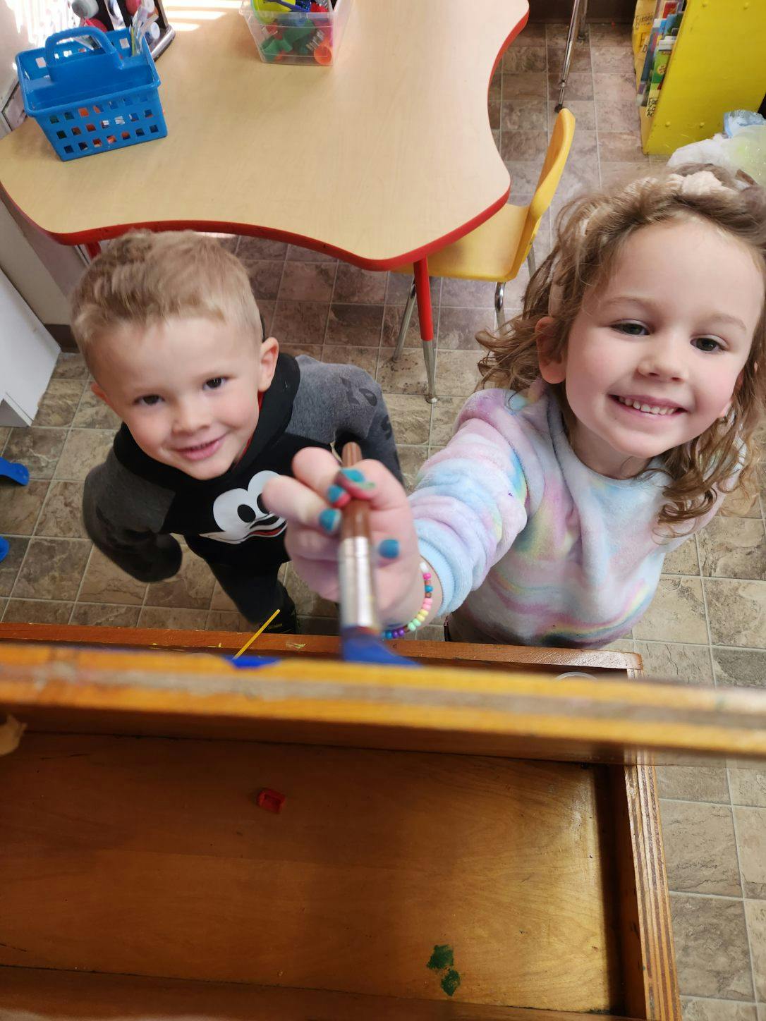 Two children painting with brushes