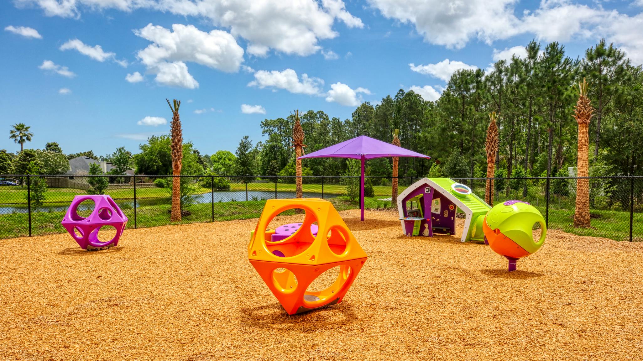 Playground with colorful geometric climbing structures on wood chips