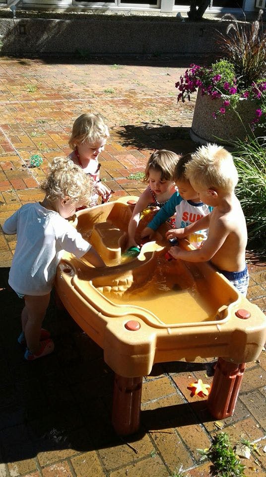 Children playing at a water table outdoors