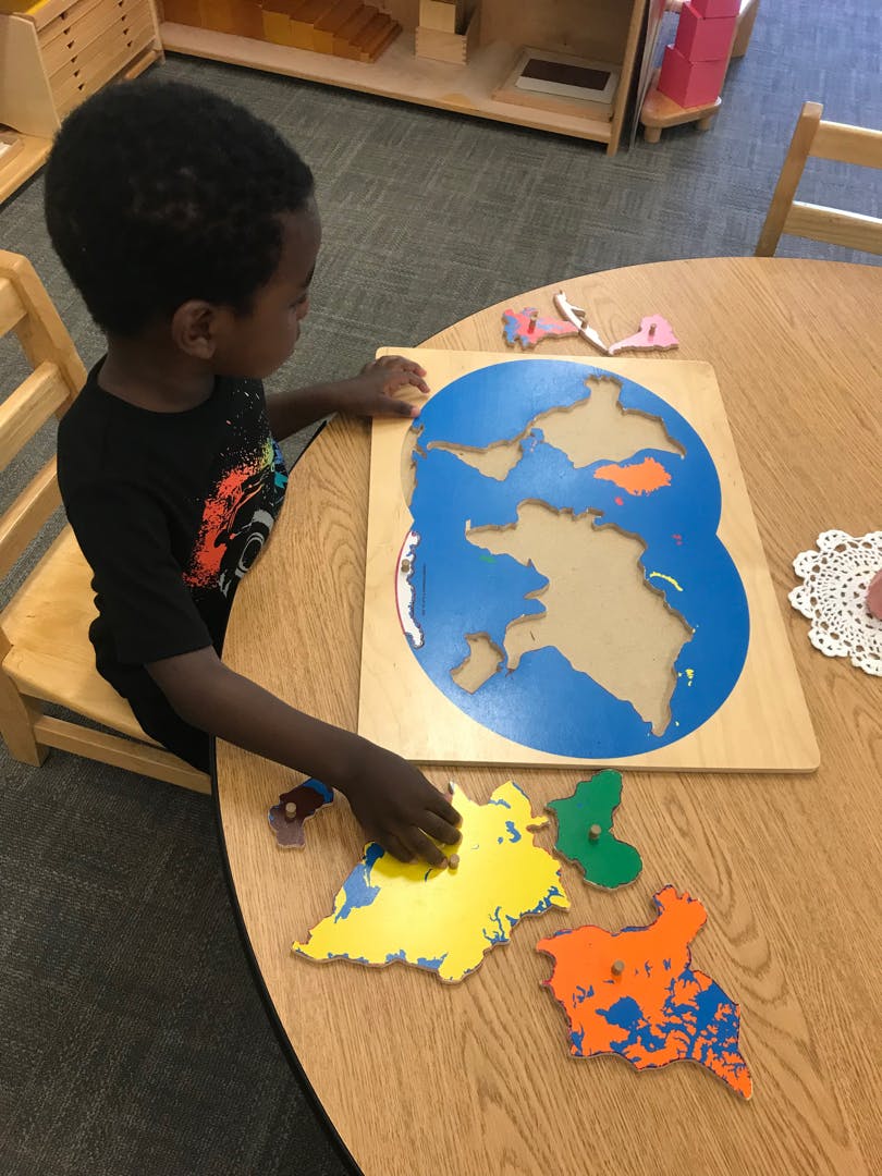 Child playing with a world map puzzle