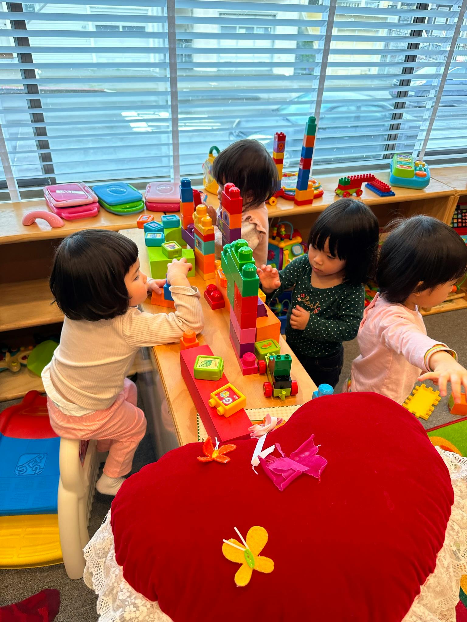 Children playing with colorful building blocks at a table