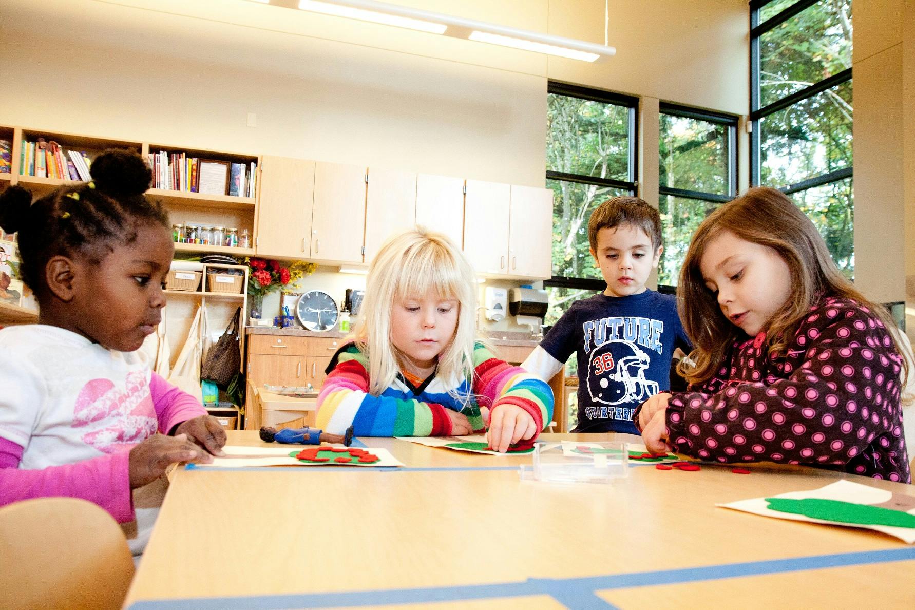 Four children sitting at a table playing a game