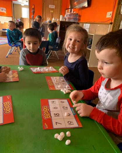 Children playing Bingo at a table