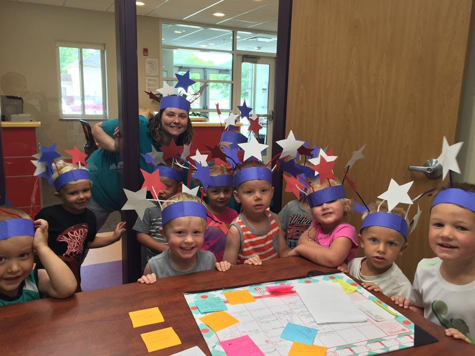 Person and children wearing star headbands at a table
