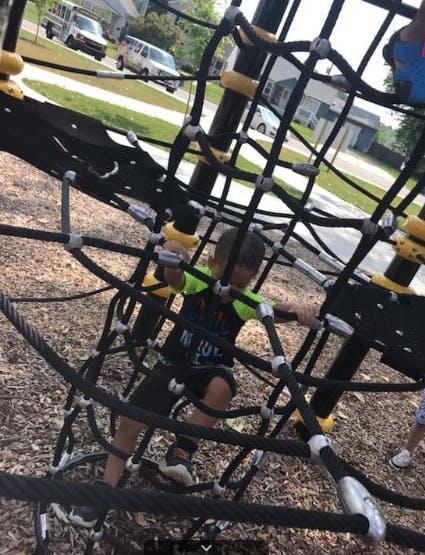 Child climbing on a rope playground structure