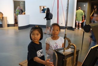 Two children standing next to an exhibit