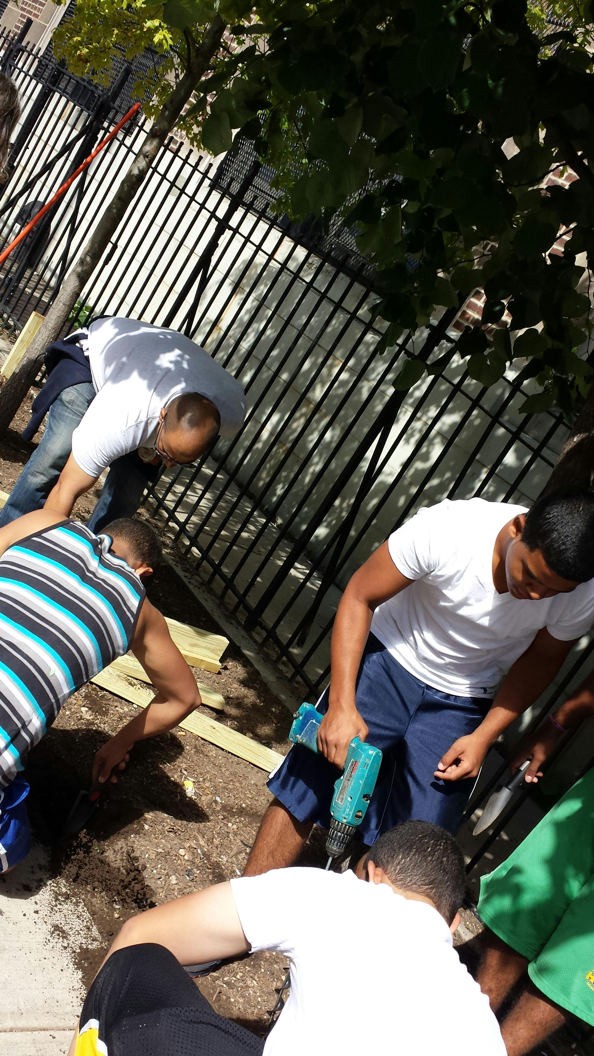 People working outdoors, one person holding a drill