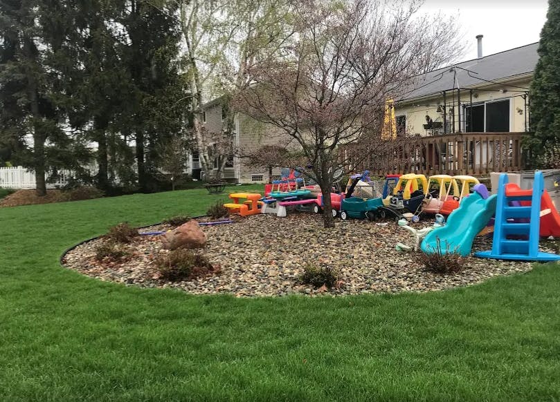 Backyard with a play area featuring slides and ride-on toys