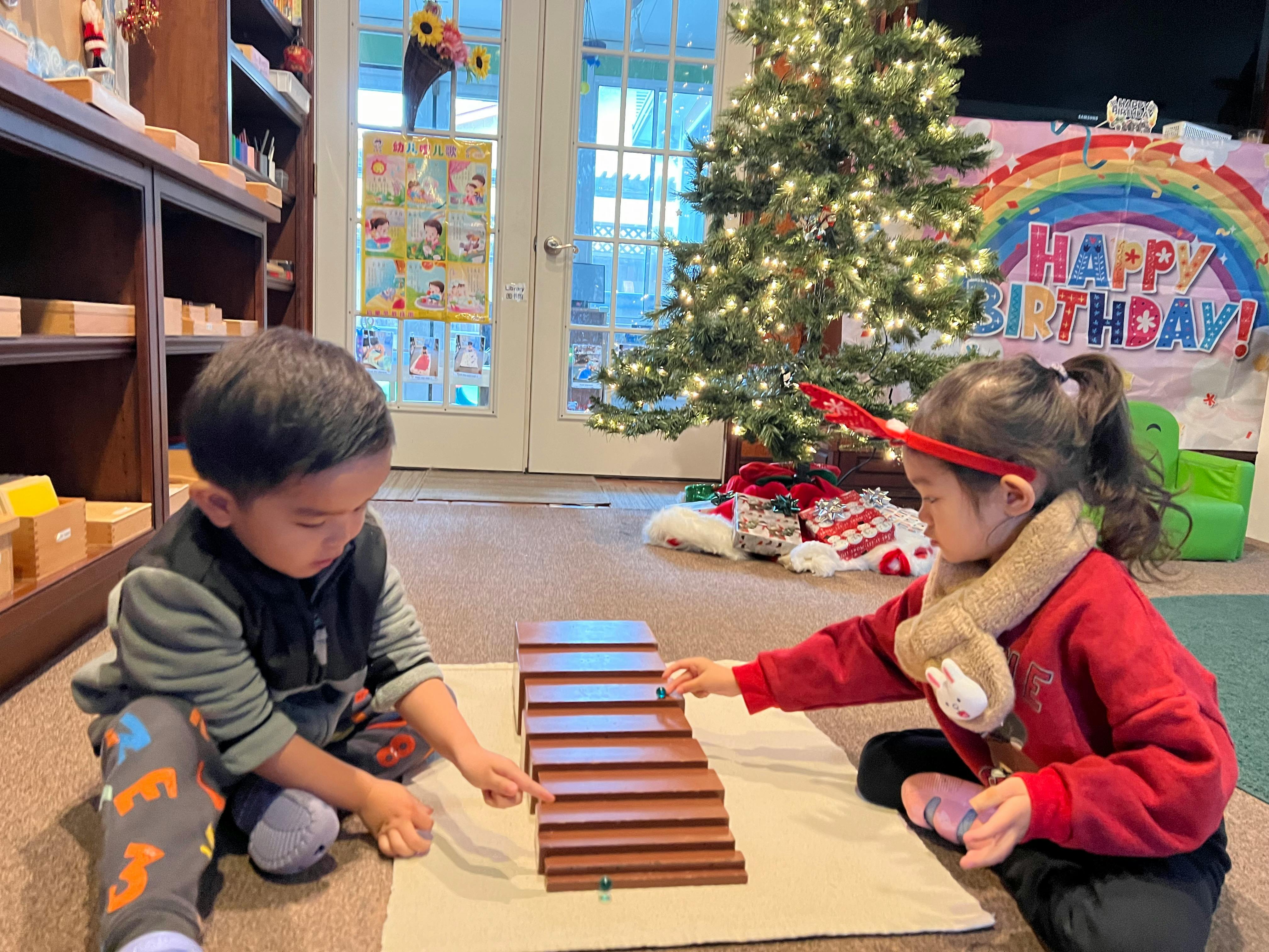 Two children playing with wooden blocks on the floor