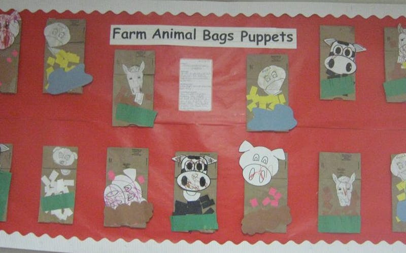 Farm animal paper bag puppets on a red bulletin board