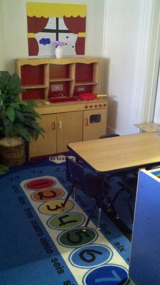 Play kitchen set with a table and chairs on a numbered rug