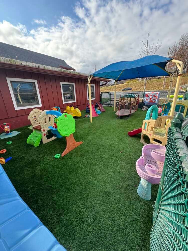 Outdoor playground with various colorful play structures on artificial turf