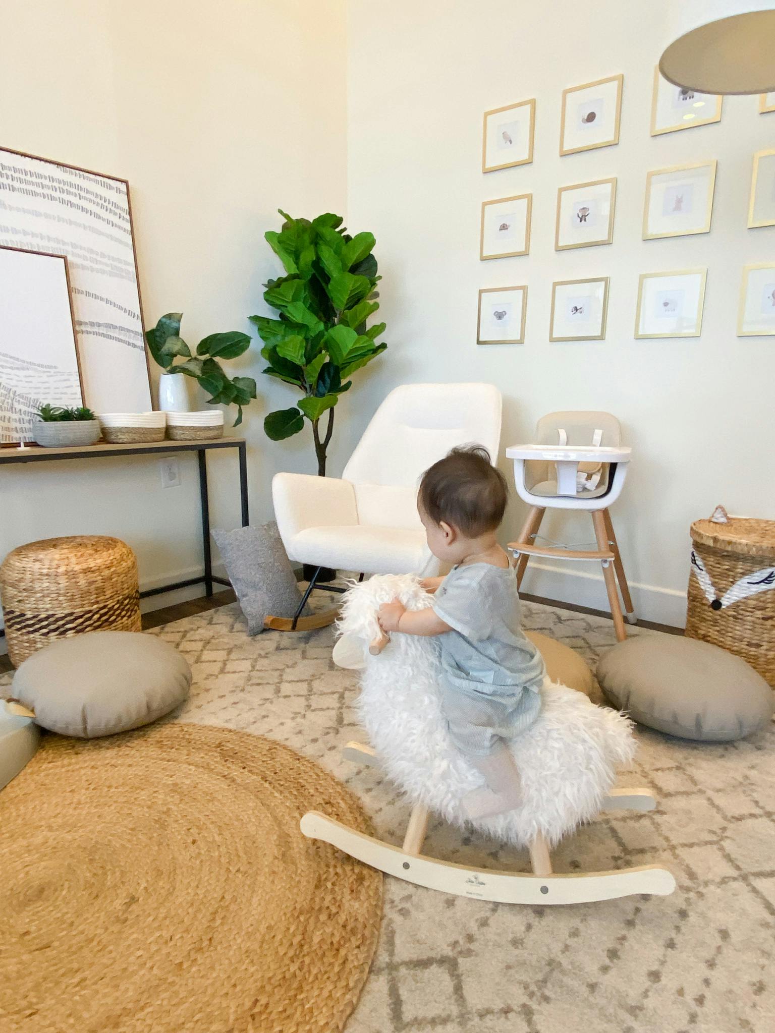Child on a white rocking sheep toy in a room
