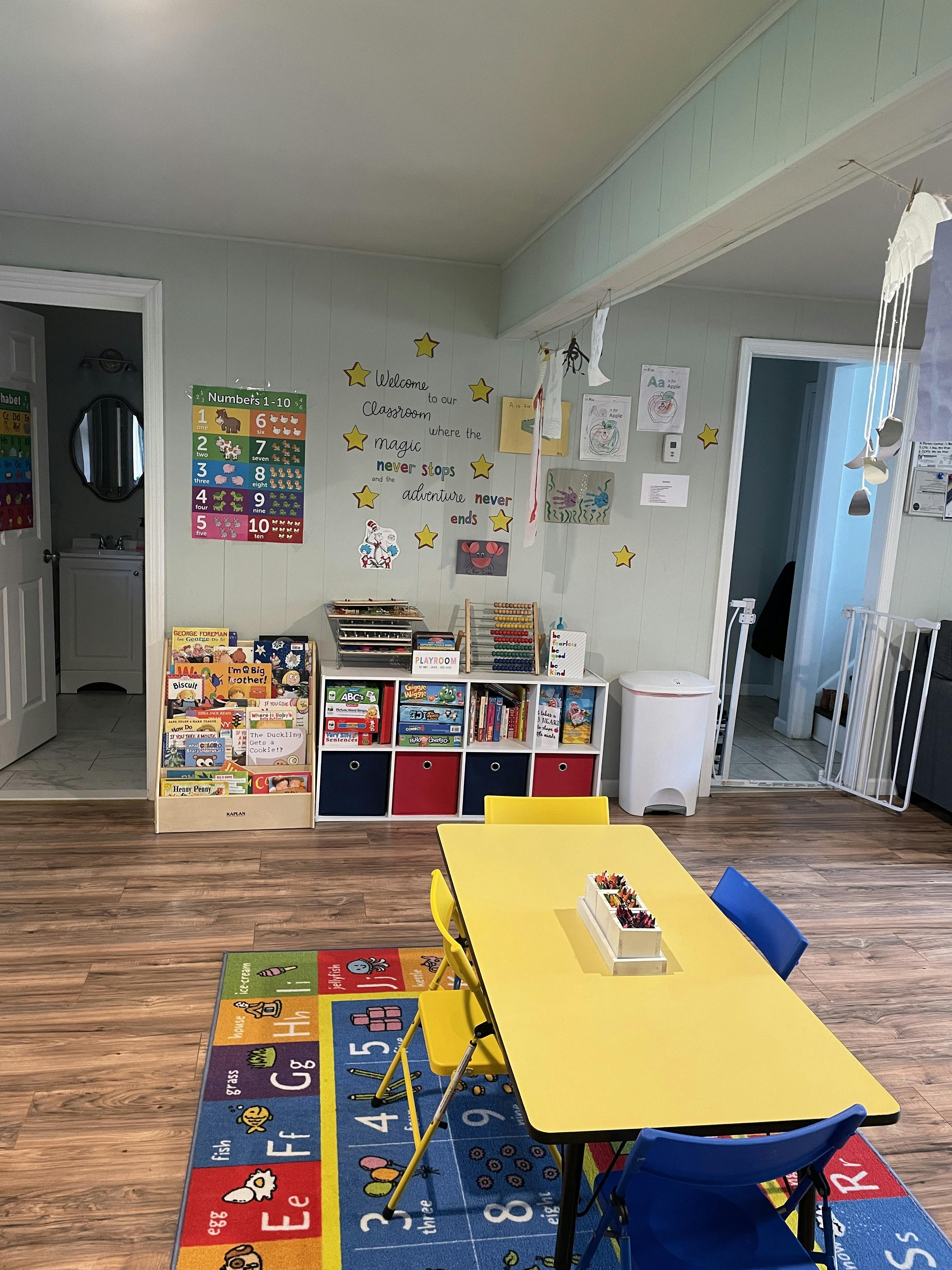 Children's classroom with a yellow table and colorful rug
