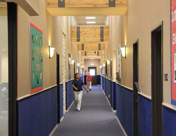 Two people walking down a long hallway