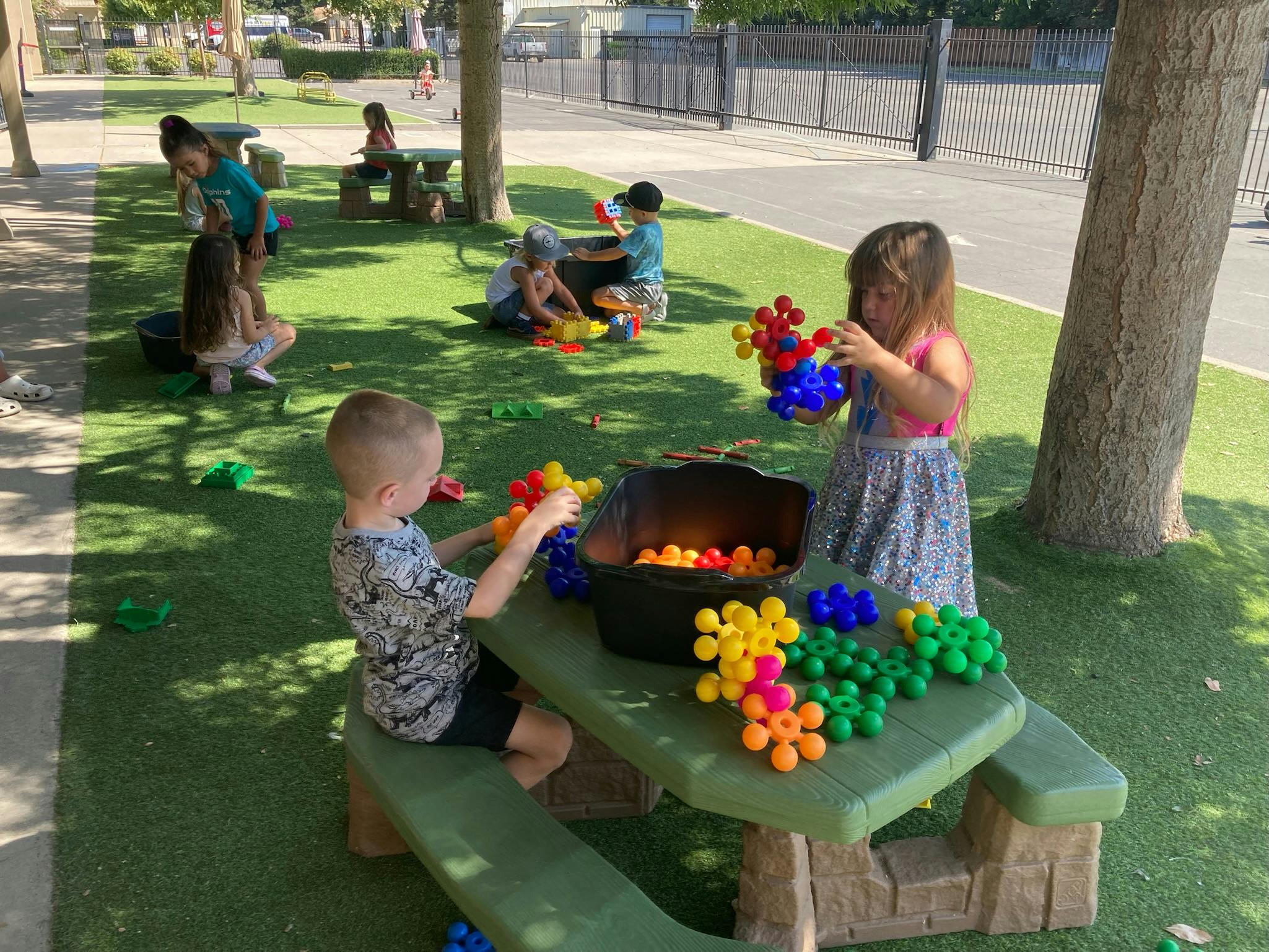 Children playing with colorful building toys outdoors