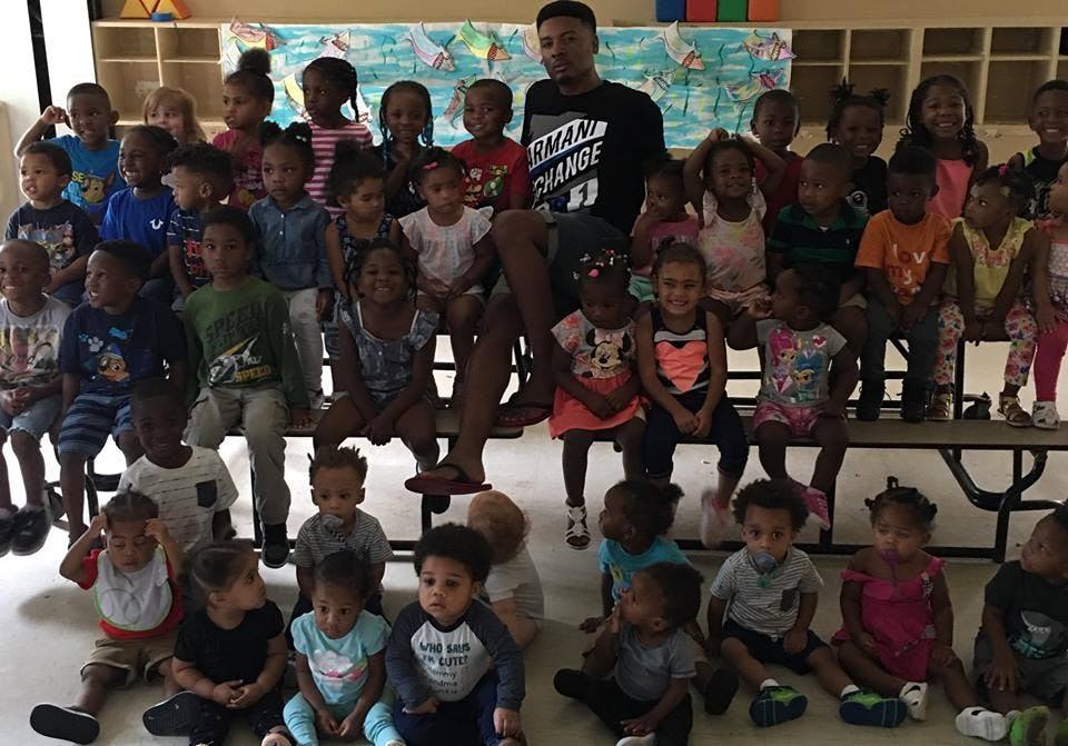 Adult and many children posing for a group photo