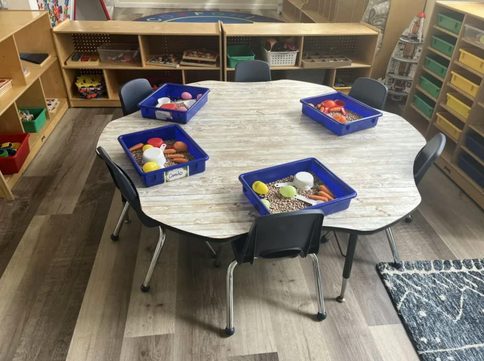Classroom table with four bins of sensory materials and toys