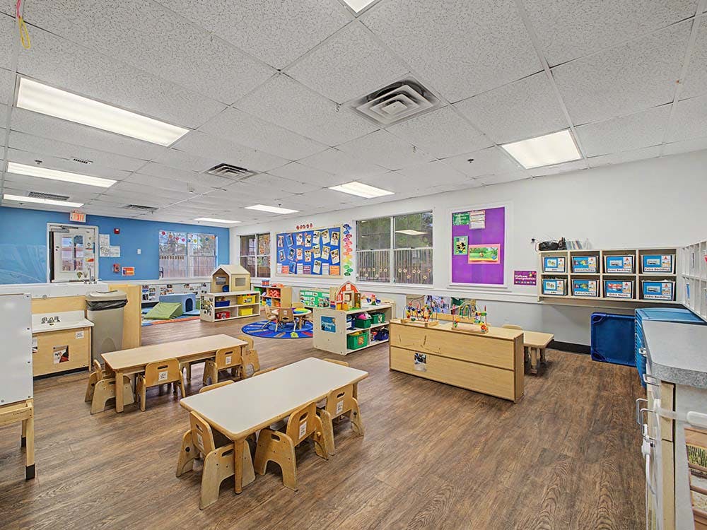 Empty colorful preschool classroom with small tables and chairs