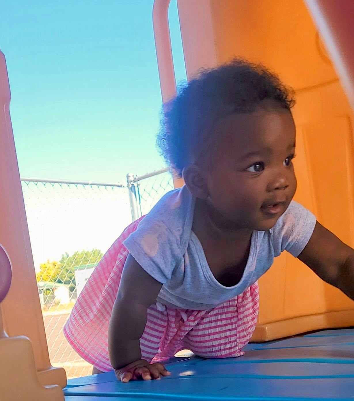 A young child crawling on a play structure
