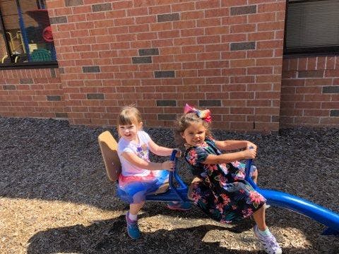 Two children on a blue seesaw