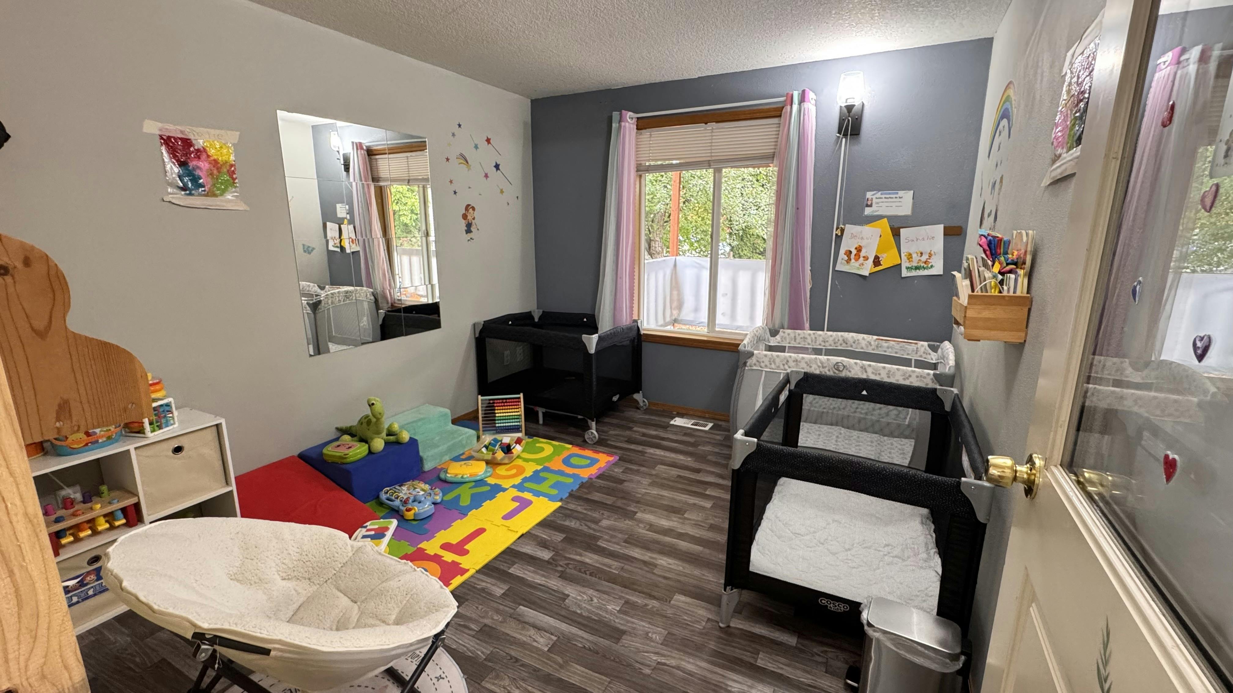 Nursery room with multiple cribs and play area