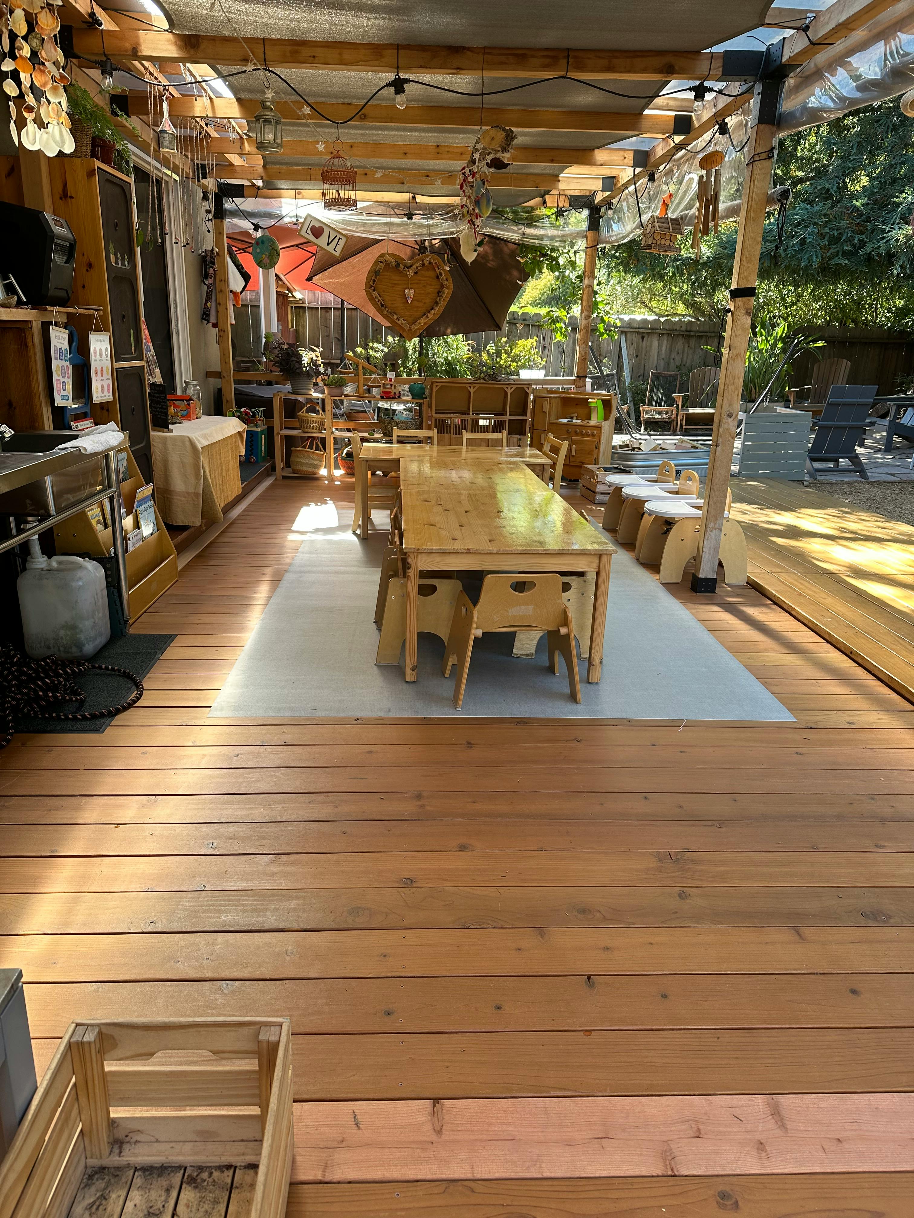 Outdoor dining area with wooden tables and chairs on a wooden deck