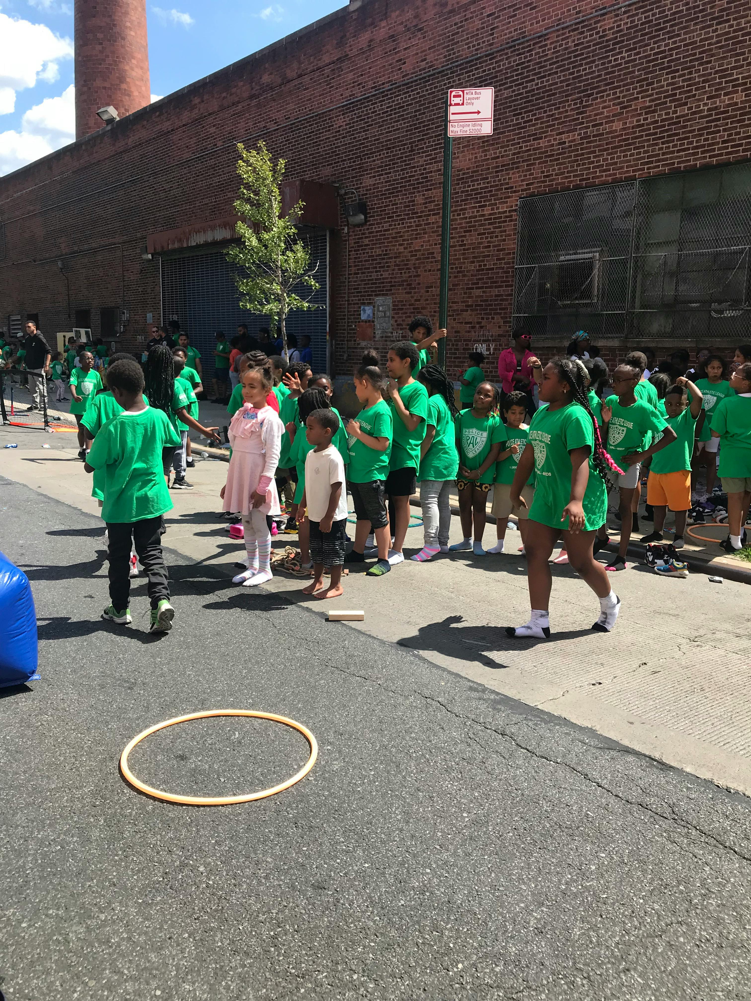 Group of children standing on a street next to a brick building