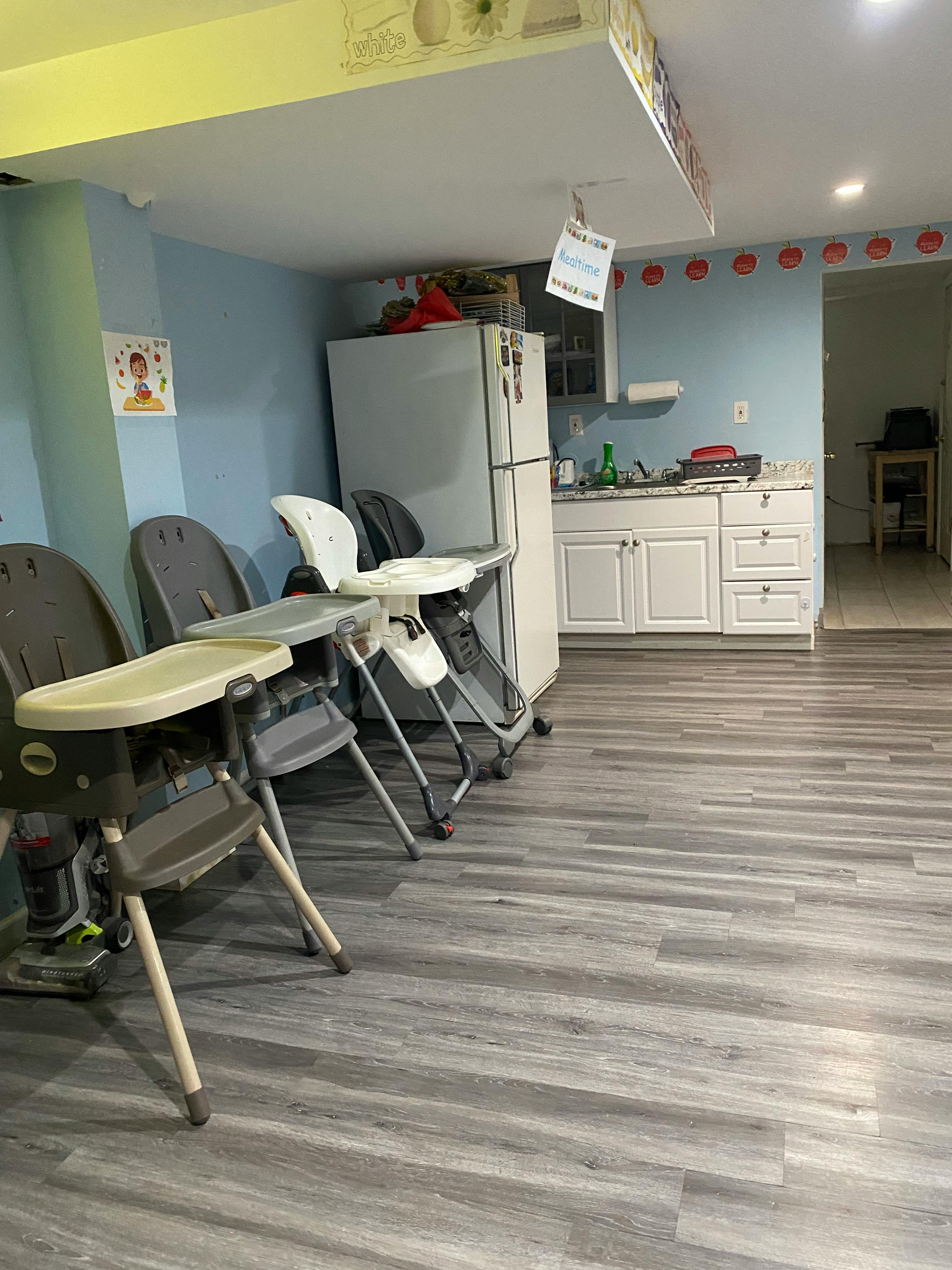 Three high chairs in a room with a refrigerator and kitchen counter
