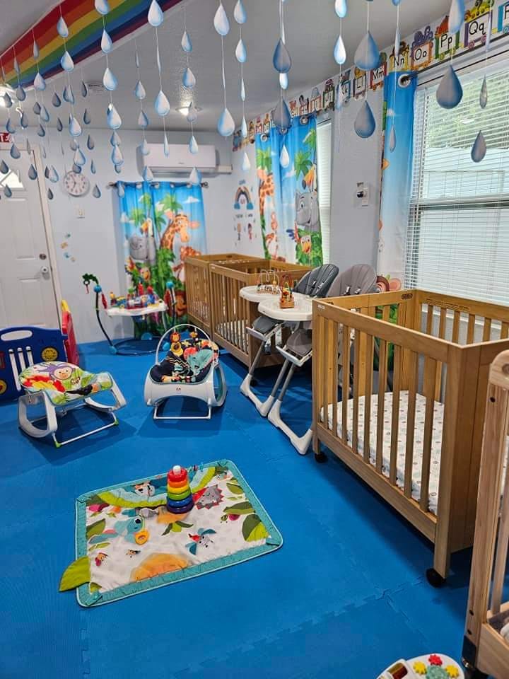 Nursery room with multiple cribs, high chairs, and play mats