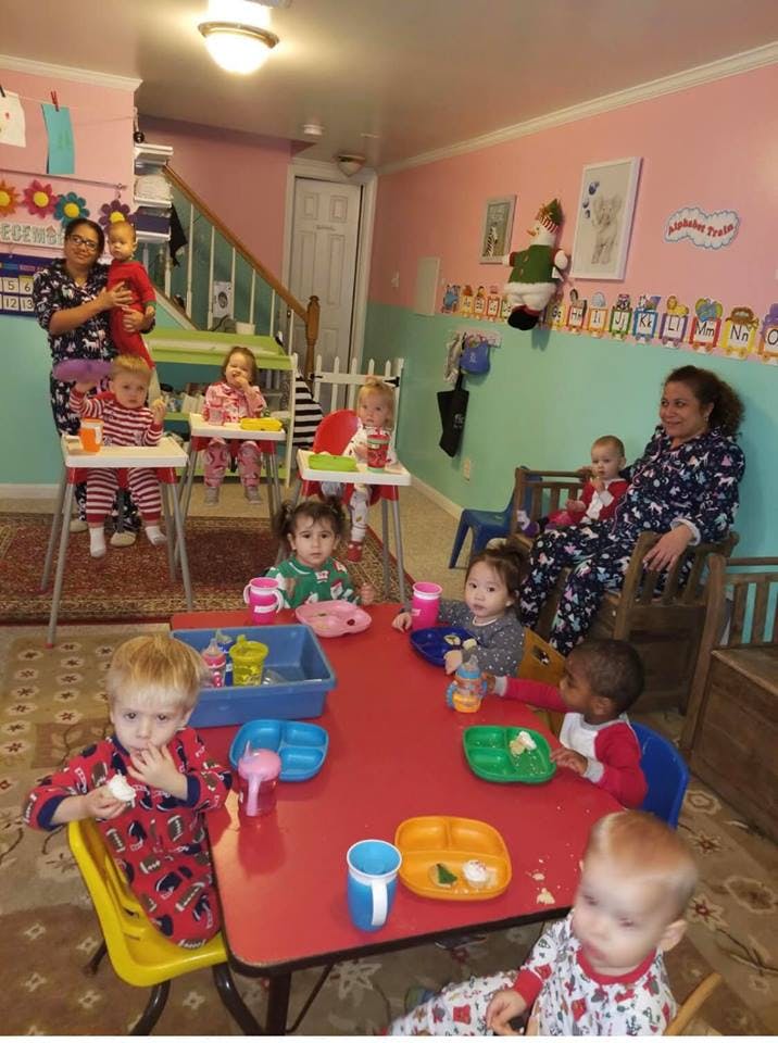 Adults and children in a room with some children seated at a red table