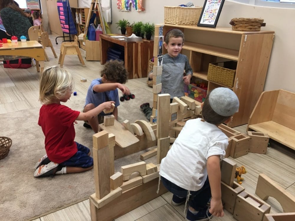 Children playing with wooden blocks in a classroom