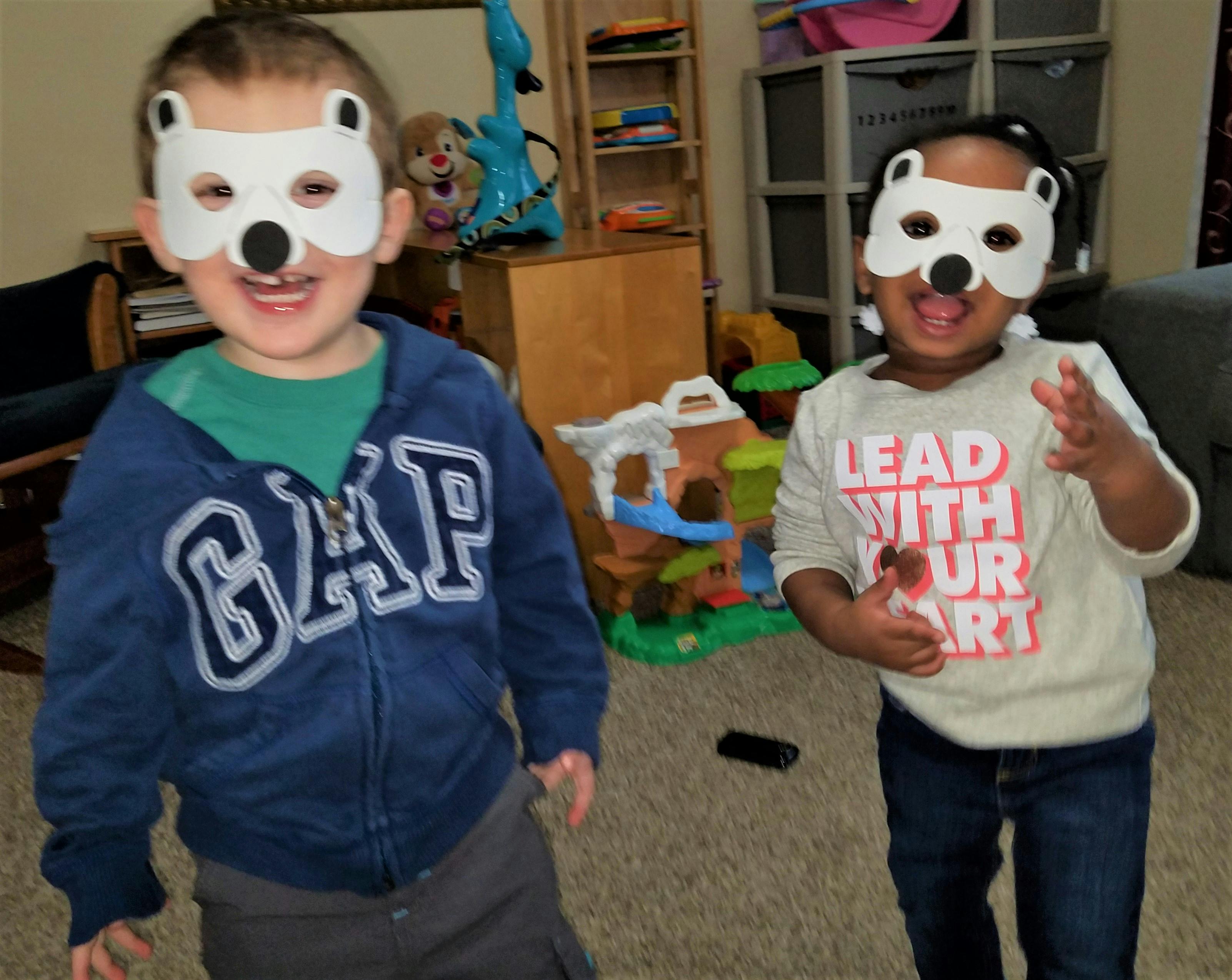 Two children wearing white bear masks