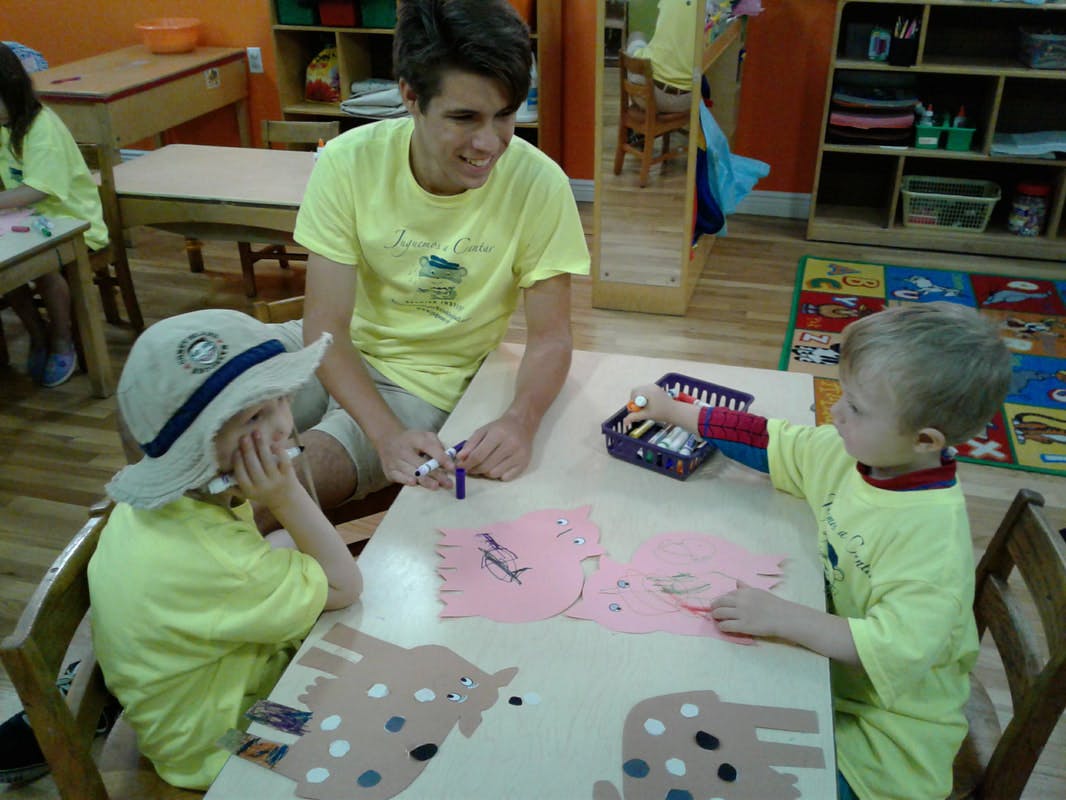 Person and two children doing crafts at a table