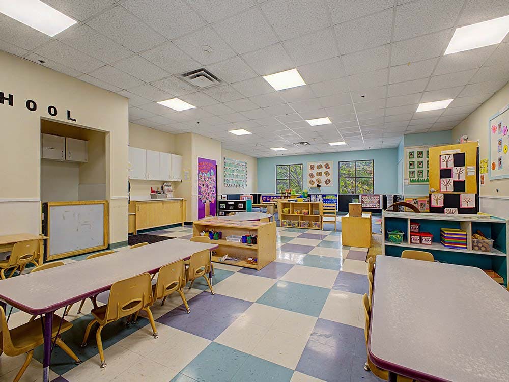 Empty colorful classroom with small tables and chairs