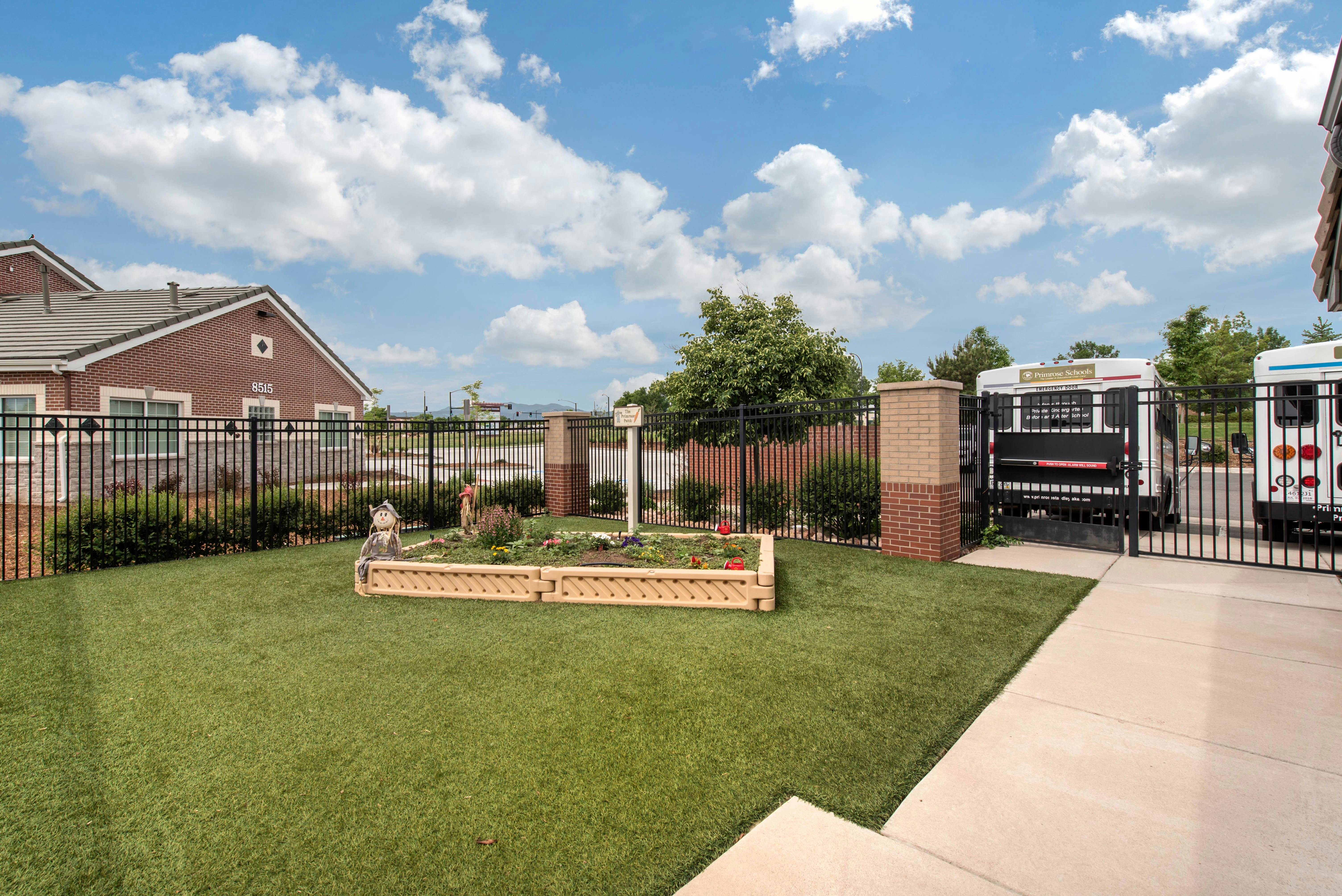 Fenced yard with a garden bed, artificial turf, and a building labeled 8515