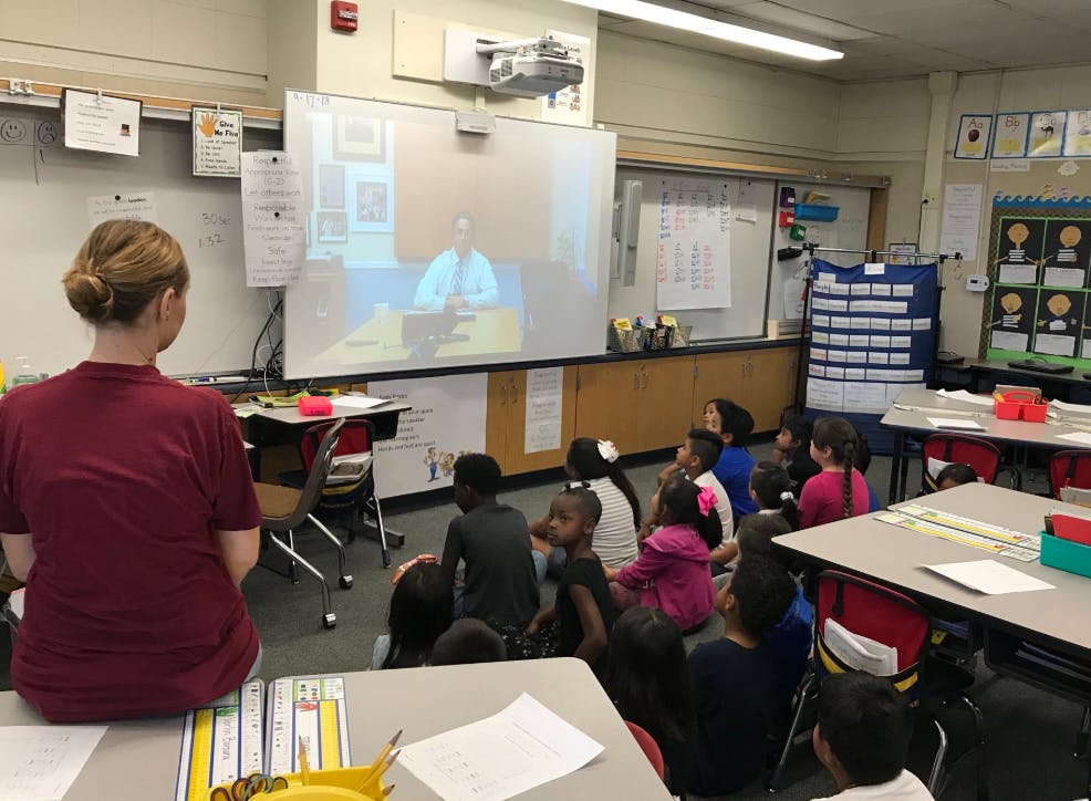 Person and children watching a video in a classroom