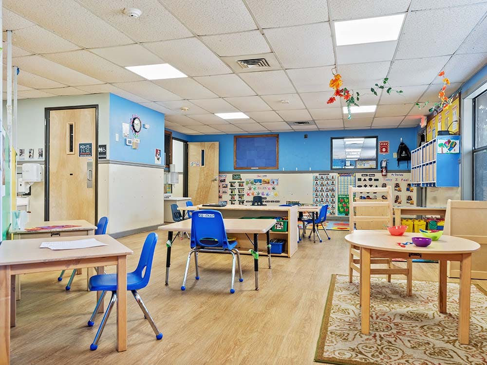 Empty classroom with small tables and blue chairs