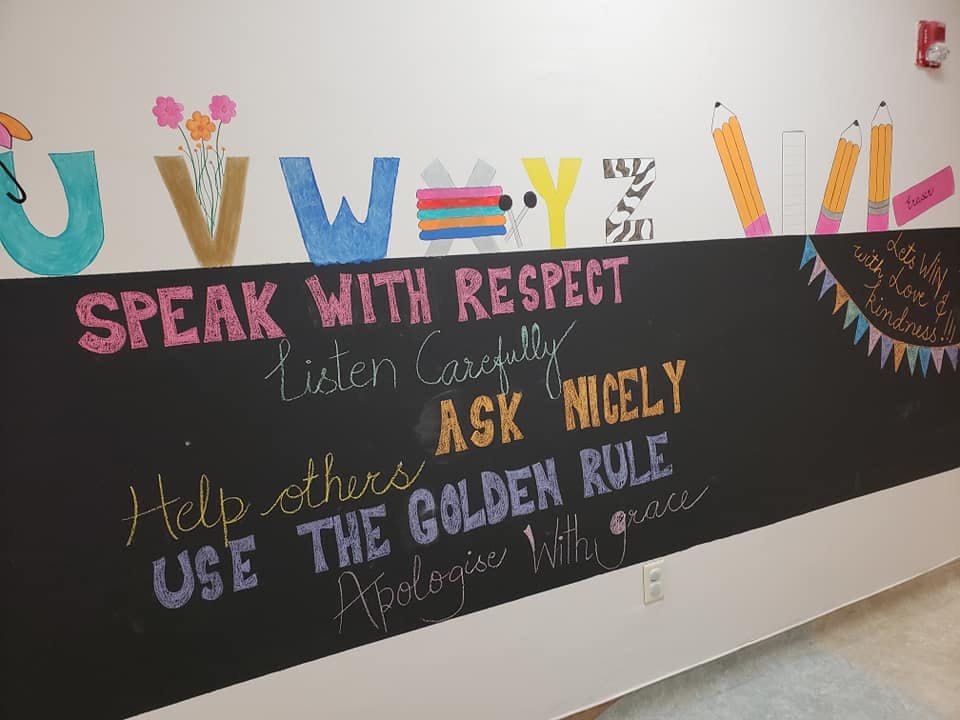 Chalkboard wall with rules including "Speak with respect" and "Ask nicely"
