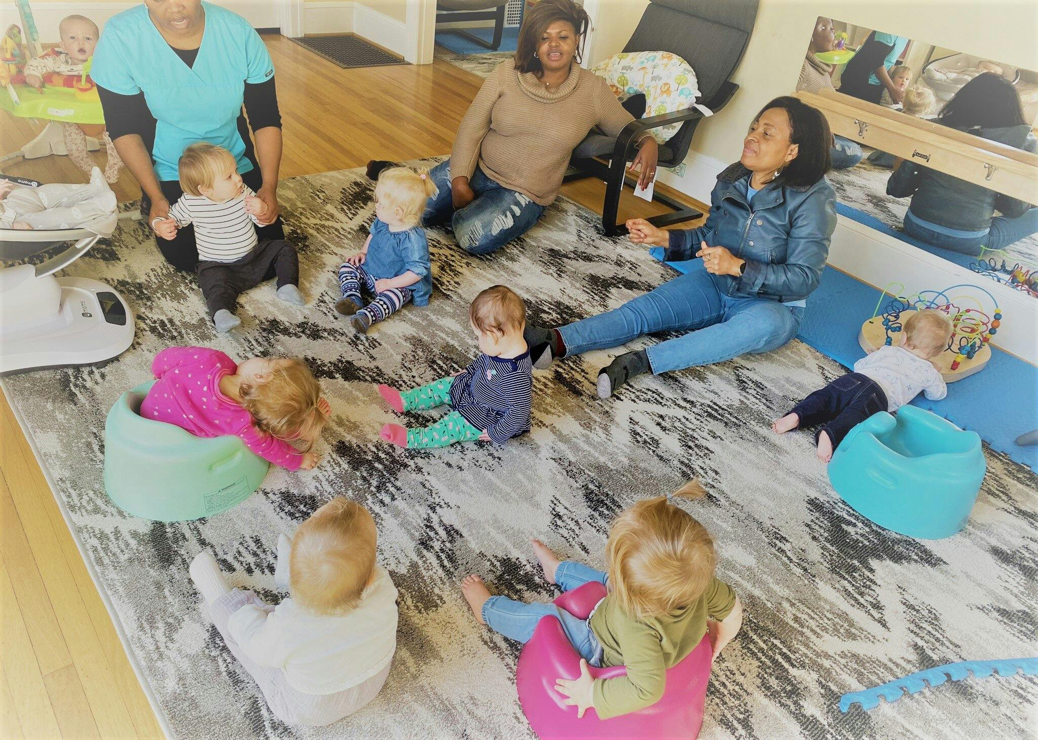 Adults and children sitting on a rug