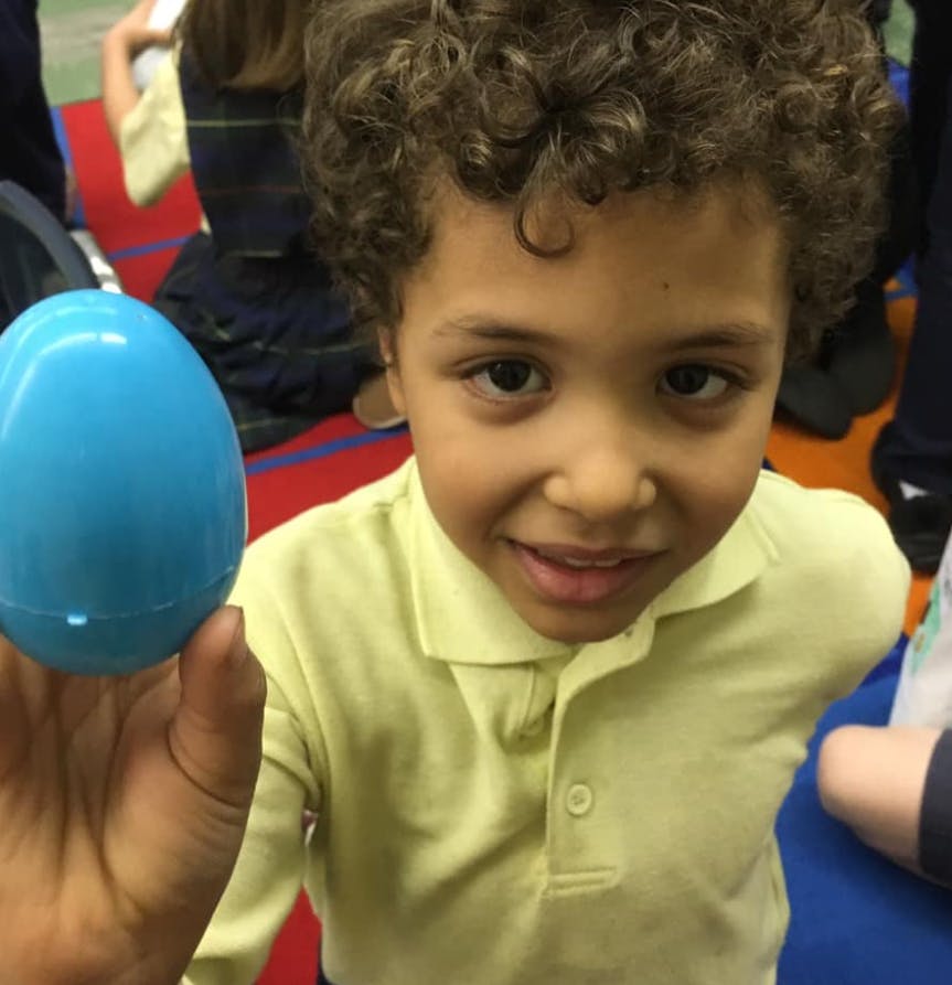 Child holding a blue plastic egg