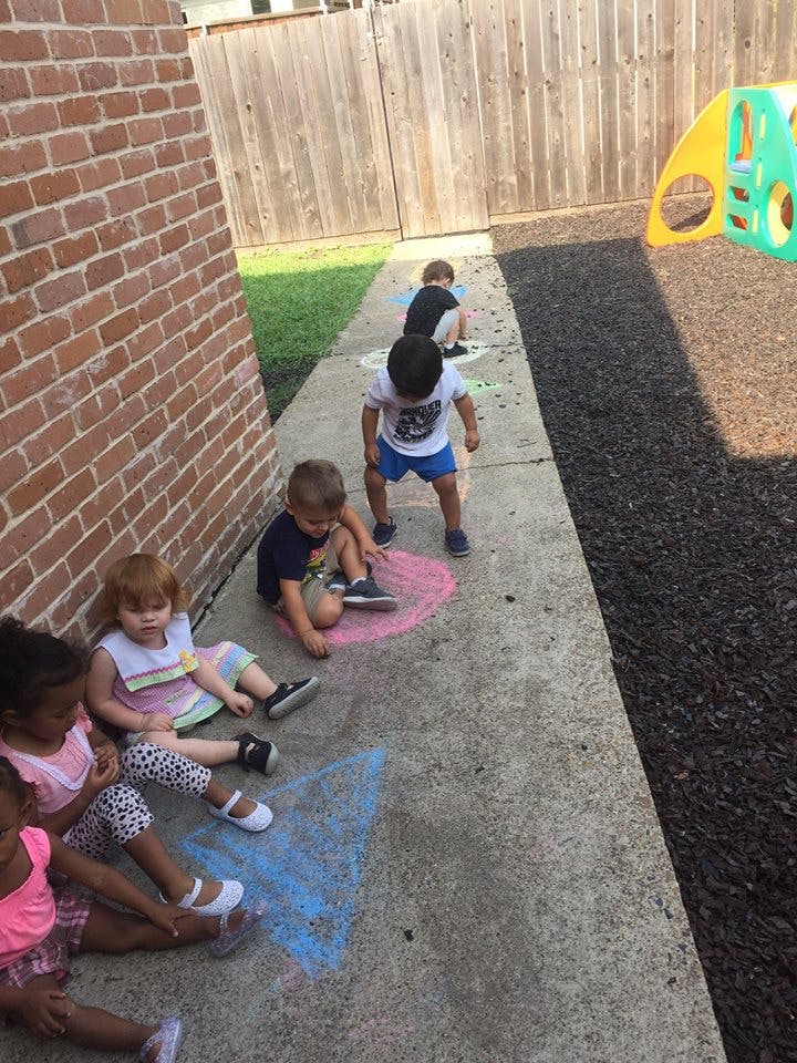 Children drawing with chalk on a sidewalk
